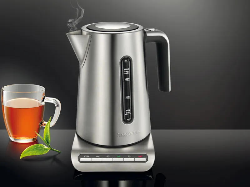 bollitore elettrico in acciaio con base staccabile e di fianco una tazza di te